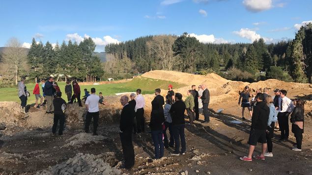 A group of people standing around the start of the earthworks at the Waipa Valley Development